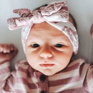 A baby in striped pajamas stretches out.