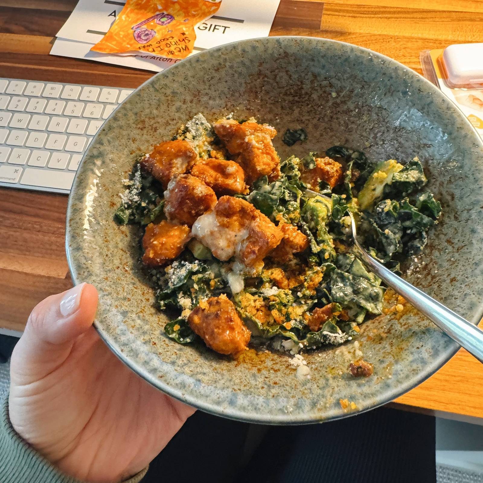Buffalo tofu and kale caesar salad in a bowl.