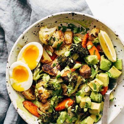 Roasted Vegetable Bowls with Green Tahini and a side of egg and a spoon in the bowl.